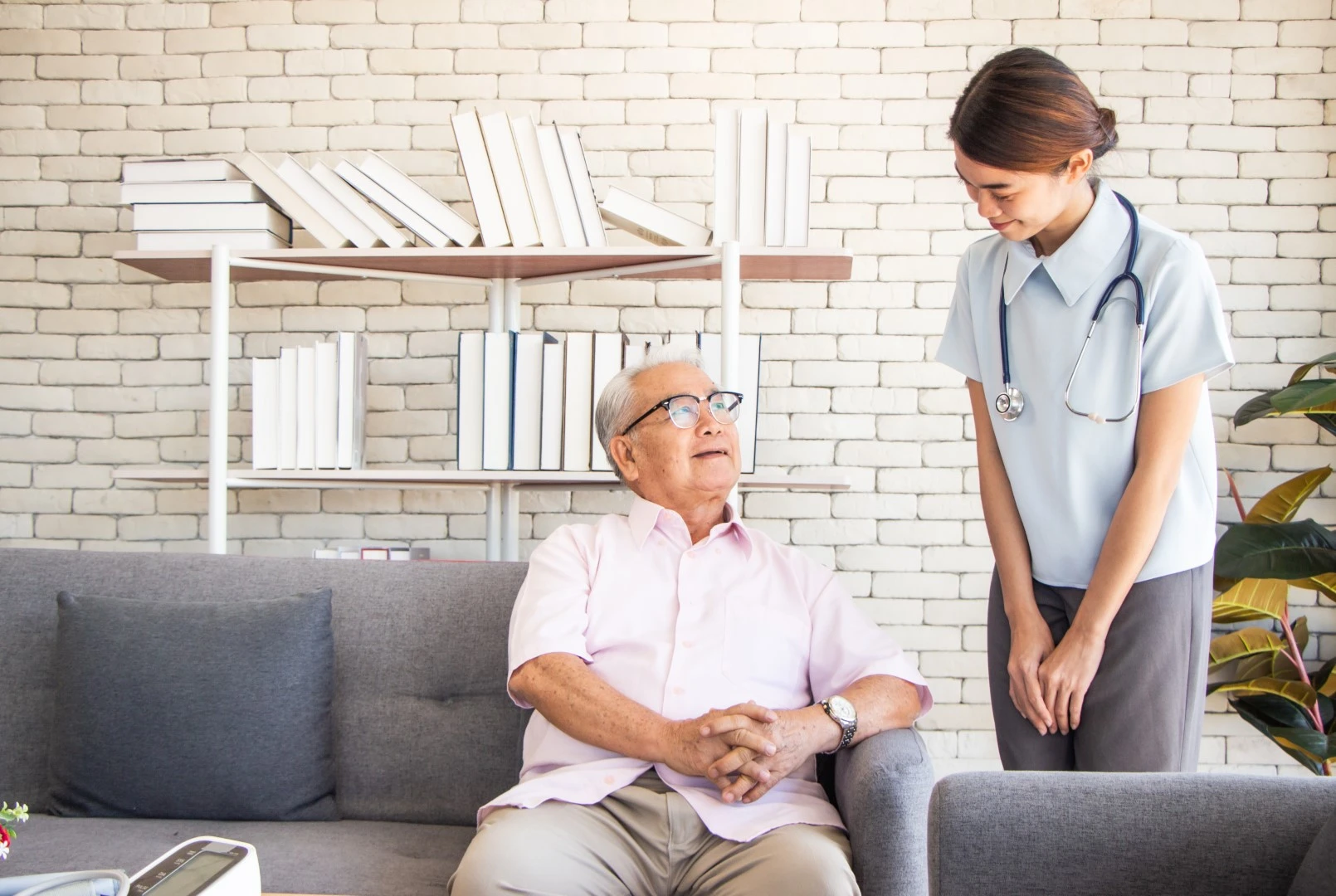 Elderly man sitting on a couch talking with a lady, showcasing durable, stain-resistant, easy-to-clean USA quality furniture supplied by GOLDEN AGE HOUSING PRODUCTS